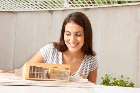 A female architect looking at a model houseの写真素材