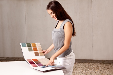 A female interior architect or designer looking at rug samples from a catalogueの写真素材