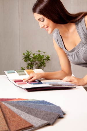 A female interior designer looking at rug samples from a catalogueの写真素材
