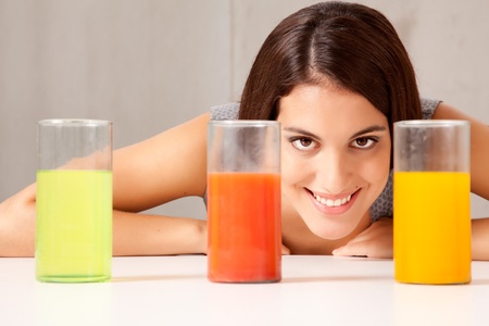 Three glasses with colorful liquid - woman doing experiementの写真素材
