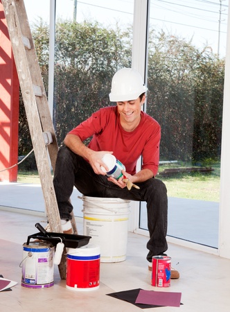 A man with a hard hat, indoors ready to paintの写真素材