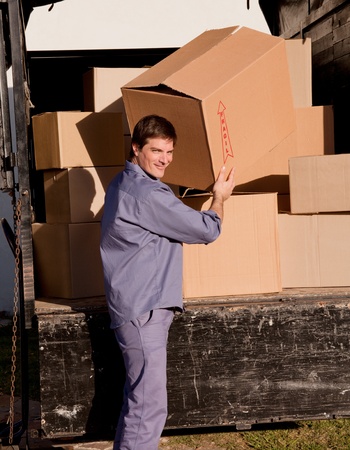 A portrait of a professional mover carrying cardboard boxesの写真素材