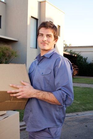 Portrait of a serious man outdoors with cardboard moving boxesの写真素材