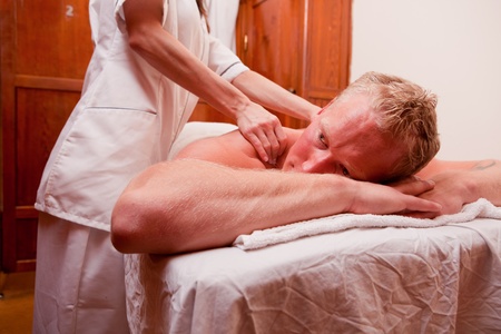 A man receiving a shoulder and back massage at a spaの写真素材