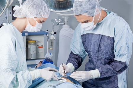 Medical professionals carrying on surgery on patient in operation theatreの写真素材
