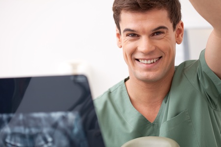 Dentist with xray in hand, smiling at the cameraの写真素材