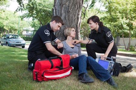 Emergency medical professionals assessing an injured patient on the streetの写真素材