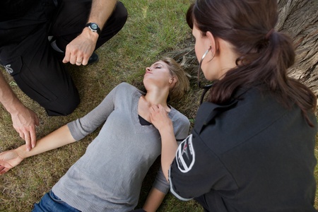First responder medical team attending to sick womanの写真素材