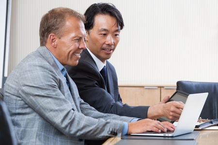 Two multi-ethnic colleagues working together on a computerの写真素材