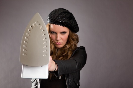 Attractive female model holding iron out in frontの写真素材