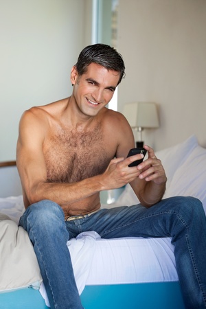 Portrait of shirtless man using cell phoneの写真素材