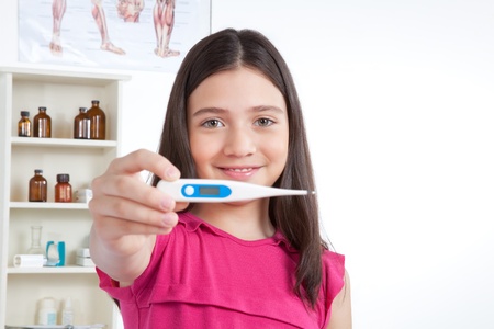 Portrait of girl showing thermometer in clinic 