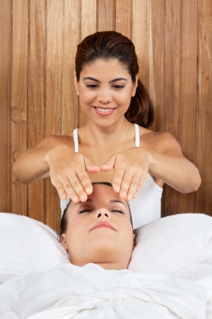 Young woman receiving massage from a female masseur at health spaの写真素材