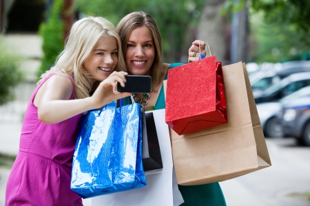 Shopping Women taking self portrait with cell phone の写真素材