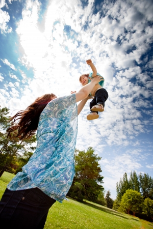 Pregnant mother in third trimester playing with her daughter in a parkの写真素材