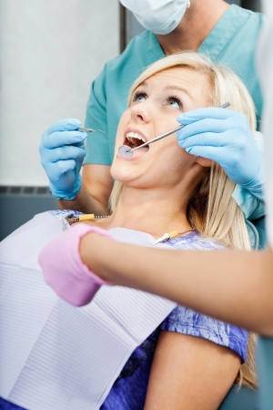 Dentists Treating A Female Patient At Clinicの写真素材