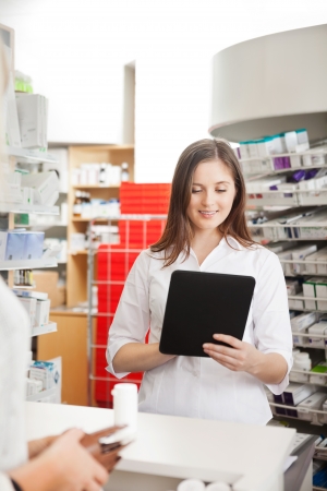 Pharmacist Helping Customer with Digital Tabletの写真素材