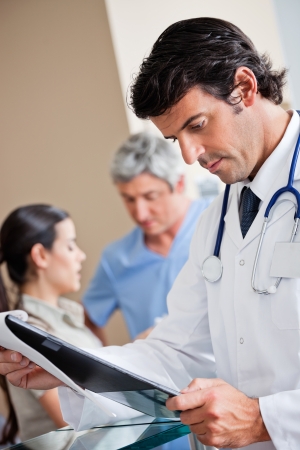 Doctor Reading Document At Receptionの写真素材