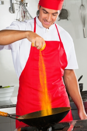 Chef Adding Turmeric Powder In Panの写真素材