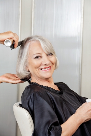 Senior Woman Getting Hair Styled In Salonの写真素材