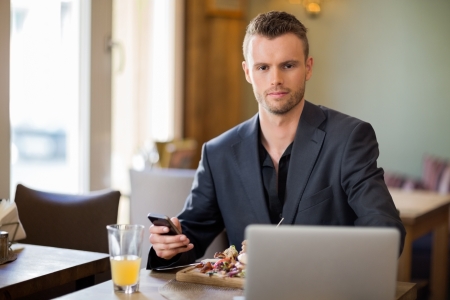 Young Business man With Mobilephone And Laptop In Coffeeshopの写真素材