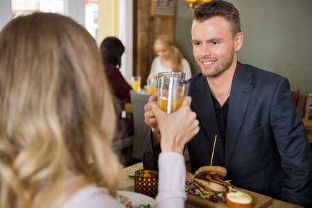 Businessman Toasting Juice Glasses With Female Colleagueの写真素材