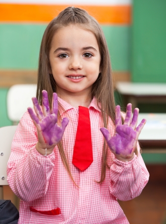 Girl Showing Colored Hands In Classroomの写真素材