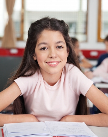 Schoolgirl Sitting At Desk In Classroomの写真素材