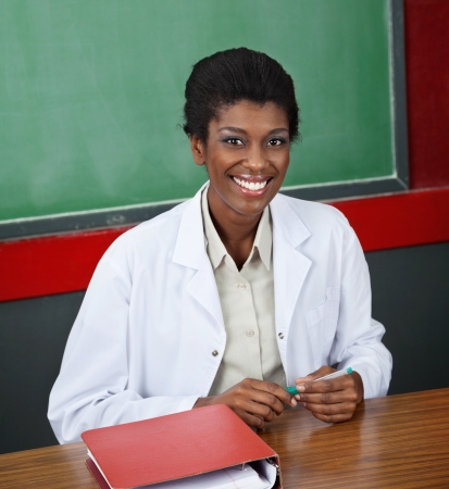 Confident Female Professor Sitting At Deskの写真素材