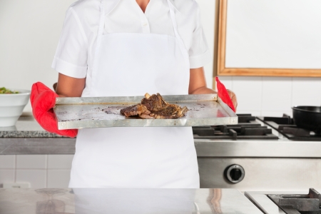 Female Chef With Tray Of Roasted Meatの写真素材