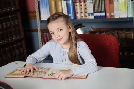 Little Girl Sitting At Table With Booksの写真素材
