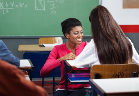 Teacher Teaching Teenage Schoolgirl At Deskの写真素材
