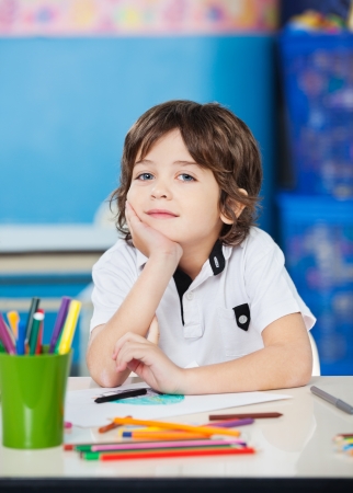Boy Sitting With Hand On Chin In Drawing Classの写真素材