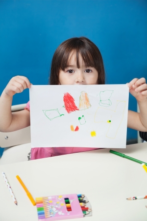 Girl Showing Drawing Paper In Classroomの写真素材