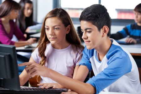Boy With Female Friend Pointing At Computer Screenの写真素材