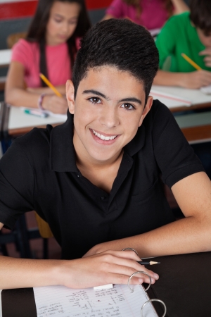 High School Student Smiling While Sitting At Deskの写真素材