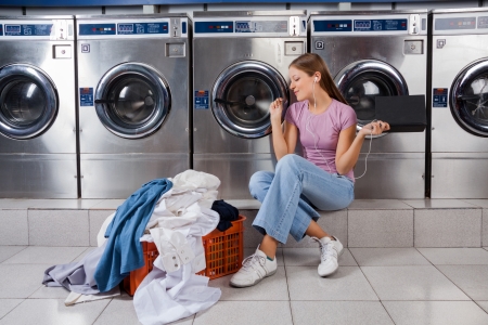 Woman Enjoying Music In Laundryの写真素材