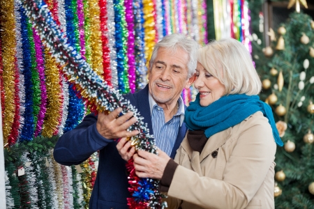 Senior couple selecting tinsels at Christmas storeの写真素材