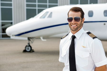 Confident pilot smiling in front of private jetの写真素材