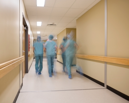 Blurred motion of medical team walking in hospital corridorの写真素材