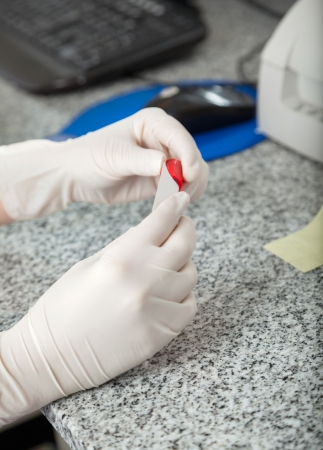 Cropped image of female lab technician labeling test tubeの写真素材