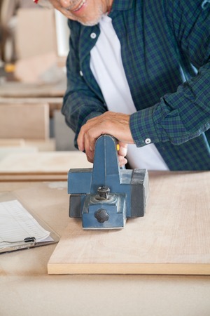 Carpenter Working With Electric Planer In Workshopの写真素材
