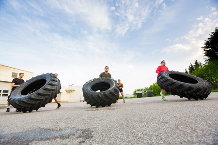 Athletes Doing Tire-Flip Exerciseの写真素材
