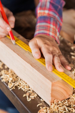 Carpenter\'s Hand Marking On Wood In Workshopの写真素材