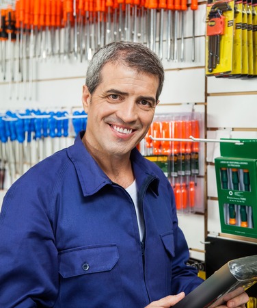 Confident Worker Holding Product In Hardware Storeの写真素材
