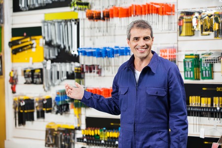 Worker In Overalls Gesturing In Hardware Storeの写真素材