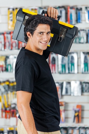 Smiling Man Carrying Toolbox On Shoulder In Store