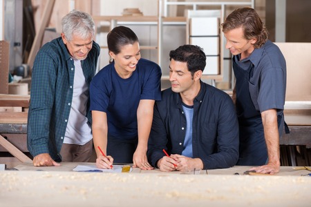 Carpenters Working Together On Blueprintの写真素材