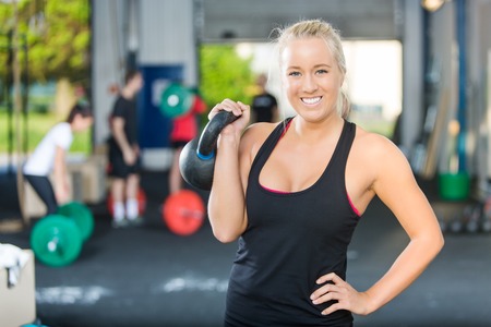 Happy Female Athlete Lifting Kettlebellの写真素材