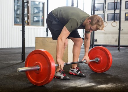 Man Picking Barbell in Gymの写真素材